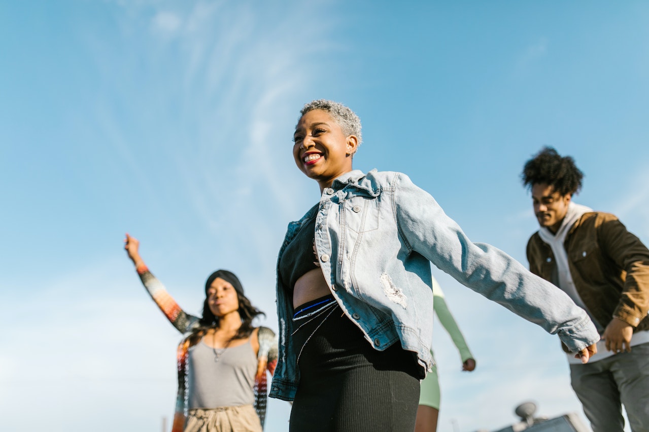 Smiling Woman in Denim Jacket Dancing with Friend