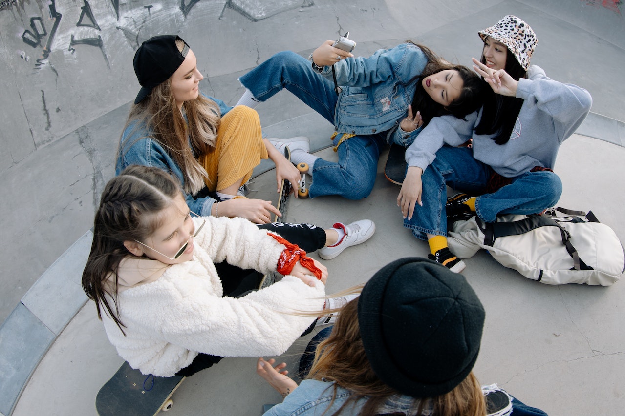 Group of Friends Having Fun Sitting on Skate Park