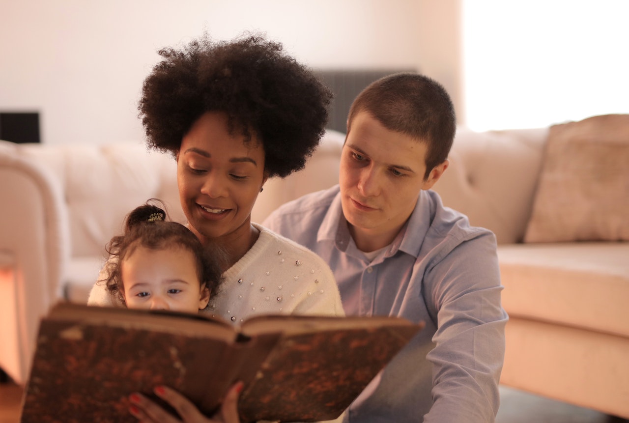 A couple reading short poems to their daughter