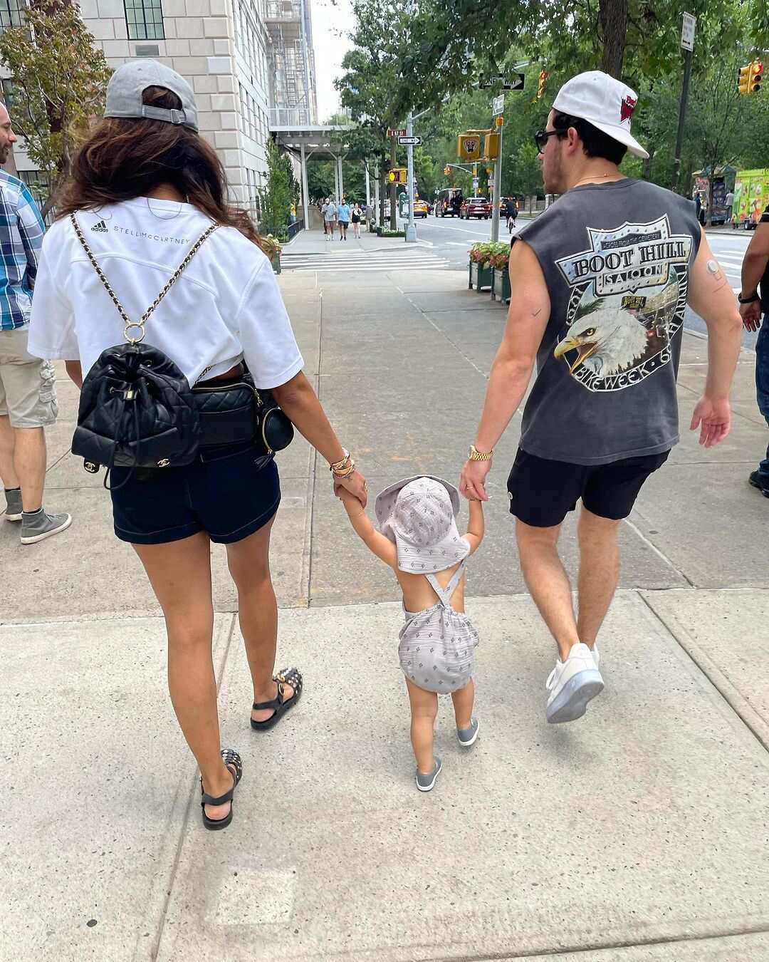 Priyanka Chopra and Nick Jonas holding Malti Marie's hands