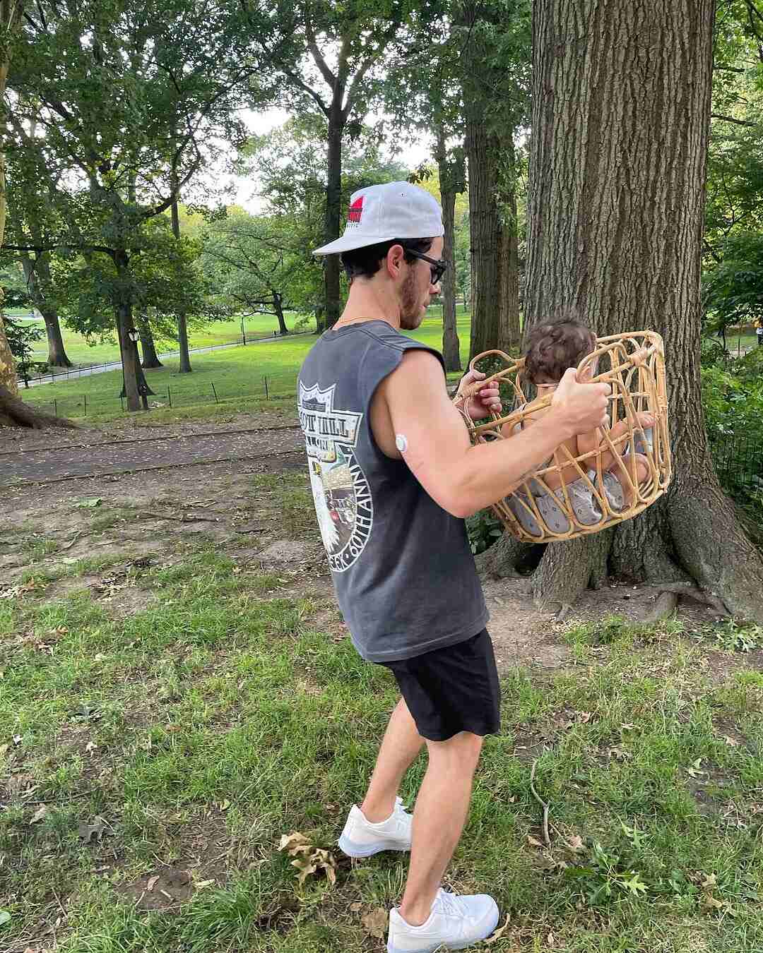 Nick Jonas carrying Malti Marie in a basket