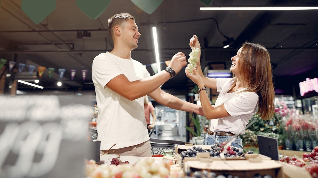 Smiling couple buying fruits in grocery store