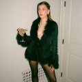 Hailey Bieber in black fur jacket and mini-skirt with a hint of sparkle is the ultimate look to cruise through party season 