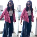Mira Rajput in a white top layered with a pink shirt and denim flared pants is making traveling look so stylish