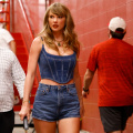 Taylor Swift turns game day into a runway in Versace denim corset, shorts and red knee-length boots 